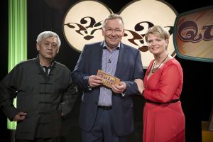 Lindenstra&szlig;e: Moderator Bernd Stelter begrüßt Gabi (Andrea Spatzek) und Gung (Amorn Surangkanjanajai) in seiner Quizshow.