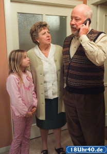 Lindenstraße: Erich (Bill Mockridge) fragt in der Schule nach den Prüfungsergebnissen. Helga (Marie-Luise Marjan) und Lea (Anna Sophia Claus) hören gespannt zu.